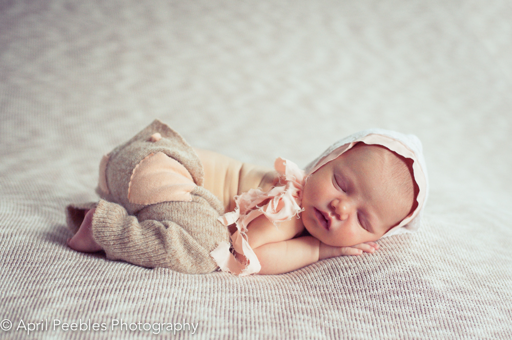 newborn image in tan and peach bonnet and pants