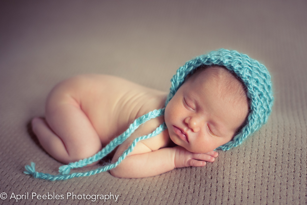 Newborn Photography Session Image with Turquoise Bonnet